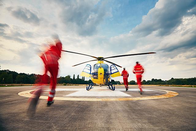 Paramedics running towards a helicopter image